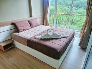 a bed in a room with a large window at Baan Khaoyai by Chateau in Ban Tha Maprang