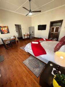 a large bedroom with a large bed and a desk at Toni's Cottage in Graaff-Reinet