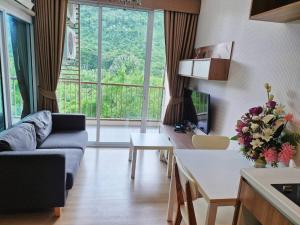 a living room with a couch and a table at Baan Khaoyai by Chateau in Ban Tha Maprang