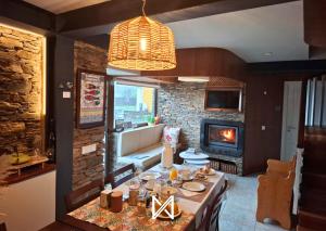 a dining room with a table and a fireplace at MyStay - Campus Natura in Arganil
