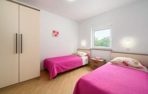 two beds in a small room with pink sheets at Villa Roberta by Villas Guide in Pazin