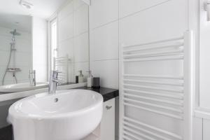 Un baño blanco con lavabo y ducha en Zindering Renesse, en Renesse 20 fotos más