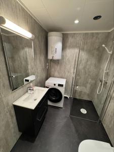 ein Badezimmer mit Dusche, Waschbecken und Toilette in der Unterkunft Arctic Sea Apartments in Hammerfest