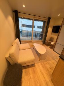 ein Wohnzimmer mit einer Couch und einem Tisch und einem Fenster in der Unterkunft Arctic Sea Apartments in Hammerfest