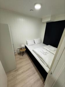 ein Schlafzimmer mit einem großen Bett mit weißer Bettwäsche in der Unterkunft Arctic Sea Apartments in Hammerfest
