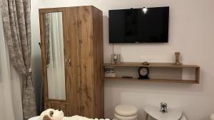 a bathroom with a toilet and a television on the wall at INNA Studio Rin Residence in Bucharest +2 photos
