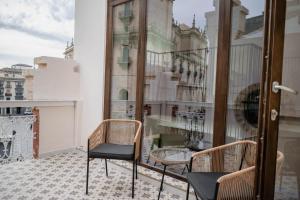 a balcony with two chairs and a table at Royar Casa del Reloj - Apartamentos Premium frente Catedral in Jaén