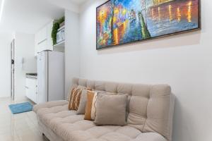 a living room with a couch and a painting on the wall at Place Beira Mar in Recife
