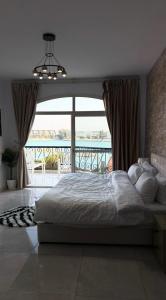 a bedroom with a large bed and a balcony at فيلا درة العروس in Dahaban