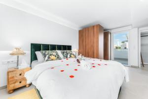 a bedroom with a white bed with red hearts on it at Villa de lujo con jacuzzi, cine, billar y futbolín in Las Casicas