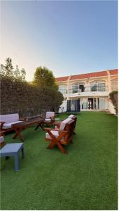 a group of picnic tables and benches in a yard at فيلا درة العروس in Dahaban