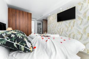 a bedroom with a bed with a tv on the wall at Villa de lujo con jacuzzi, cine, billar y futbolín in Las Casicas