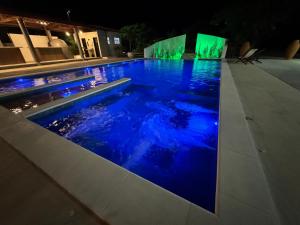a swimming pool at night with blue lights at Da terra Altos in Aracati