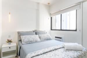 a white bedroom with a bed and a window at Place Beira Mar in Recife +33 photos