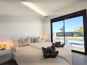 een slaapkamer met een groot wit bed en 2 handdoeken bij R-40-C Moderna in Los Montesinos +26 foto's