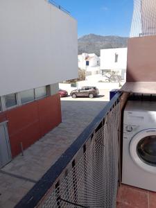 a washing machine on a balcony with a parking lot at Tamariua L2, apartamento cerca de la playa del Pas in Port de la Selva