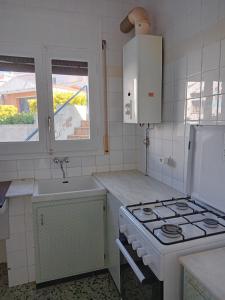 a kitchen with a stove and a sink at Tamariua L2, apartamento cerca de la playa del Pas in Port de la Selva