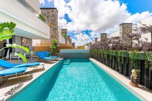 a swimming pool with lounge chairs and a swimming poolvisor at Villa de lujo con jacuzzi, cine, billar y futbolín in Las Casicas