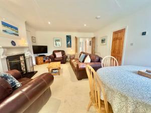 ein Wohnzimmer mit Sofa und Tisch in der Unterkunft CYNEFIN- 3 Bed, 2 Bath-1 x En-Suite, DETCAHED BUNGLAOW- PET FRIENDLY in Trearddur