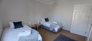 a room with two beds in a room with a door at Priai Longa 34 Self Catering in Langstrand