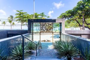 a building with a glass door and some plants at Place Beira Mar in Recife