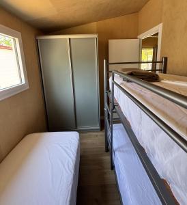 a room with two bunk beds and a refrigerator at Camping La Rueda in Cubelles +31 photos