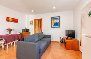 a living room with a couch and a tv at Terrace Villa with Sea View in Santa Luzia