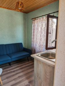 a bathroom with a sink and a blue couch at Zeyvə Farm House 