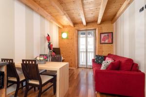 een woonkamer met een rode bank en een tafel bij La Locandiera in Carona