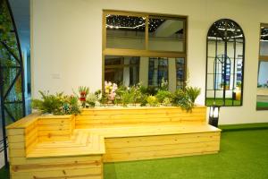 um banco de madeira com plantas em um edifício em Experience a New Level of Comfort in A m a n a h Mall Link Road Model Town em Lahore
