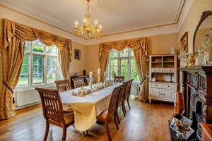 ein großes Esszimmer mit einem Tisch und Stühlen in der Unterkunft Luxury Detached House in private grounds, with SPA in Weston upon Trent