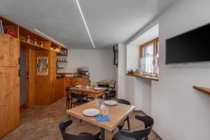 a dining room with tables and chairs and a flat screen tv at B&B Soreghina in Malè
