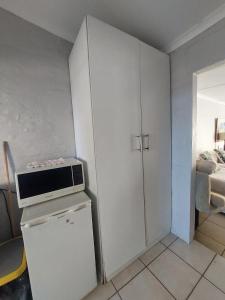 a small kitchen with a microwave on top of a refrigerator at Turtle Creek - Ridleys in Umkomaas