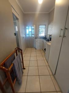 a small kitchen with a tiled floor and a sink at Turtle Creek - Ridleys in Umkomaas +2 photos