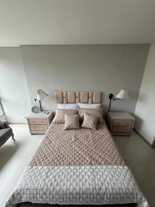 une chambre avec un grand lit avec deux tables de nuit dans l'établissement PORTANOVA SUITES - Apartamento muy cómodo, a tan sólo 5 minutos del aeropuerto JMC, à Rionegro