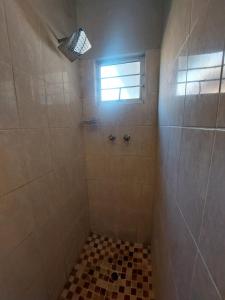 a bathroom with a shower with a window at Turtle Creek - Ridleys in Umkomaas