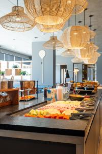 a buffet with food on a counter with chandeliers at ibis Navegantes Itajai in Itajaí