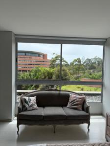 - un canapé dans une chambre avec une grande fenêtre dans l'établissement PORTANOVA SUITES - Apartamento muy cómodo, a tan sólo 5 minutos del aeropuerto JMC, à Rionegro 16 autres photos