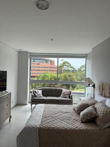 une chambre avec un lit et une grande fenêtre dans l'établissement PORTANOVA SUITES - Apartamento muy cómodo, a tan sólo 5 minutos del aeropuerto JMC, à Rionegro