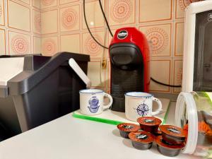 Eine Theke mit zwei Kaffeetassen und einigen Cupcakes. in der Unterkunft Casa Juliett royal terraces in Turin