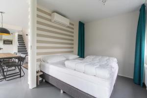 Un dormitorio con una cama y una mesa y un comedor. en Zindering Renesse, en Renesse