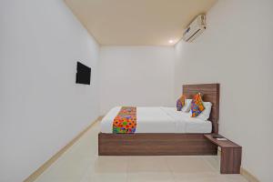 a bedroom with a bed in a white room at FabExpress Urban Inn - Yeswanthpur in Bengaluru