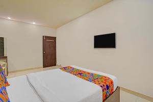 a white room with a bed with a colorful blanket at FabExpress Urban Inn - Yeswanthpur in Bengaluru