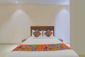 a bedroom with a bed with a colorful comforter at FabExpress Urban Inn - Yeswanthpur in Bengaluru