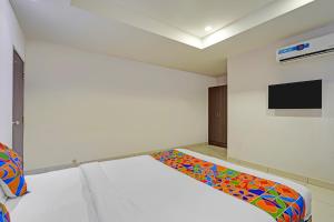 a room with a bed and a tv on a wall at FabExpress Urban Inn - Yeswanthpur in Bengaluru +18 photos