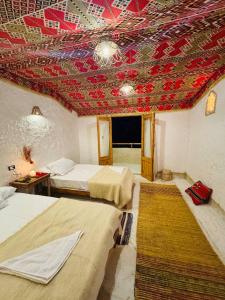 a room with two beds and a red ceiling at Esewan siwa oasis in Siwa