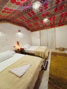 two beds in a room with a red ceiling at Esewan siwa oasis in Siwa