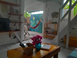 een woonkamer met een tafel met bloemen erop bij Bungalow papaye in Sainte-Anne