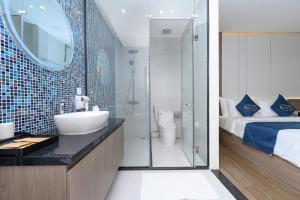 富国BayGi Phu Quoc Hotel的一间带水槽和淋浴的浴室以及一张床 更多83张照片