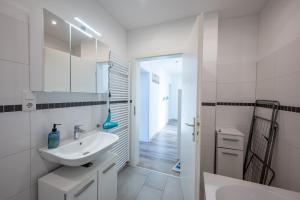 a white bathroom with a sink and a mirror at HagenStay Eilpe 1 in Hagen